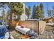 Backyard view showing wooded lot, home exterior, and storage tank behind fence at 33 L Rd, Golden, CO 80403