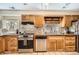 Cozy kitchen with wooden cabinetry, mosaic backsplash, stainless steel appliances, and natural light at 33 L Rd, Golden, CO 80403