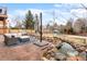 Secluded backyard featuring a pond with a waterfall, a cozy patio area, and a playhouse with a slide for outdoor entertainment at 2924 E 116Th Pl, Thornton, CO 80233