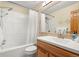 Bathroom with white tiled shower/tub combination, a white vanity and wood cabinets for comfort and function at 2924 E 116Th Pl, Thornton, CO 80233