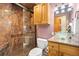 Bathroom featuring glass bowl sink, wood cabinets, and a glass enclosed shower with granite walls at 2924 E 116Th Pl, Thornton, CO 80233