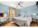 Bedroom with pale blue walls, a desk with a mirror, a bed with patterned linens, and wood flooring at 2924 E 116Th Pl, Thornton, CO 80233