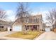 Two-story home featuring a stone facade, attached garage, and inviting porch with a well-manicured front yard at 2924 E 116Th Pl, Thornton, CO 80233