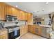 Modern kitchen featuring custom wood cabinets, granite countertops, stainless steel appliances, and tiled floors at 2924 E 116Th Pl, Thornton, CO 80233