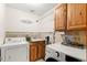 Laundry room with a washer and dryer, wooden cabinets, and decor, designed for efficient chores at 2924 E 116Th Pl, Thornton, CO 80233