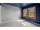 Bedroom with blue accent wall, wood-trimmed windows, and hardwood flooring at 34 Benthaven Pl, Boulder, CO 80305