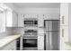 Close up of a kitchen with stainless steel appliances, light countertops, and white cabinets at 34 Benthaven Pl, Boulder, CO 80305