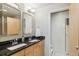 Bathroom with double vanity, granite countertops, and a tiled walk-in shower at 6946 W Alaska Dr, Lakewood, CO 80226