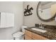 Bathroom features granite counters, oval mirror, bronze bronco art, and white subway tile in shower at 6946 W Alaska Dr, Lakewood, CO 80226