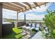 Relaxing rooftop deck offers comfortable seating around fire pit, umbrella, and artificial turf at 6946 W Alaska Dr, Lakewood, CO 80226