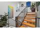 Stylish staircase with wood steps and iron railing, brightened by colorful artwork at 6946 W Alaska Dr, Lakewood, CO 80226