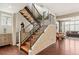 Modern staircase with wooden steps, black metal railings, and brick accent wall at 6946 W Alaska Dr, Lakewood, CO 80226