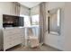 Bright bedroom featuring large window, TV, dresser, chair, and stylish mirror at 15295 W 68Th Pl, Arvada, CO 80007