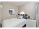 Cozy bedroom with modern round mirror, bedside table, and window with natural light at 15295 W 68Th Pl, Arvada, CO 80007