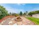 Landscaped backyard featuring a cozy fire pit area with stone accents and lush greenery for outdoor relaxation at 7270 Marmot Ridge Pl, Littleton, CO 80125