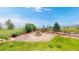 Landscaped backyard with a cozy fire pit area surrounded by lush greenery and stone accents at 7270 Marmot Ridge Pl, Littleton, CO 80125
