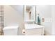 Bright bathroom featuring a marble countertop vanity, a framed mirror, and white trim at 7270 Marmot Ridge Pl, Littleton, CO 80125