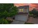Two-story home with tan siding, new brown shingle roof and inviting exterior lighting at 7270 Marmot Ridge Pl, Littleton, CO 80125