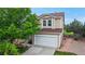 Two-story home with a two-car garage, front porch, landscaping, and driveway leading to a welcoming entrance at 7270 Marmot Ridge Pl, Littleton, CO 80125