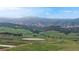 Beautiful mountain view overlooking rolling green hills with scattered trees and rock formations at 7270 Marmot Ridge Pl, Littleton, CO 80125