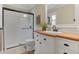 Bright bathroom featuring a walk-in shower with subway tile and a wood-counter vanity at 8132 Lodgepole Trl, Lone Tree, CO 80124