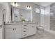 Modern bathroom with double vanity, large mirror, and walk-in shower at 6025 Ames St # A, Arvada, CO 80003