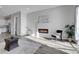 Open living room with fireplace, kitchen view, and gray flooring at 6025 Ames St # A, Arvada, CO 80003
