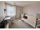 Bedroom featuring a window with sheer curtains, a small desk, and a futon at 2675 S Danube Way # 302, Aurora, CO 80013