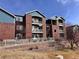 Brick condominium building featuring blue siding and white balconies on each level at 2675 S Danube Way # 302, Aurora, CO 80013