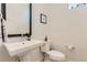 Bathroom features pedestal sink, square mirror, and white toilet in a minimalist design at 4100 E Iliff Ave # 4, Denver, CO 80222