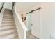 Bright entryway with a modern sliding barn door and staircase leading to the upper floors at 4100 E Iliff Ave # 4, Denver, CO 80222