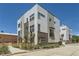 Modern townhome with mixed siding, brick accents, and large windows under a clear blue sky at 4100 E Iliff Ave # 4, Denver, CO 80222