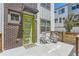 Inviting front porch with patio seating, green front door, and a welcome mat at this townhome at 4100 E Iliff Ave # 4, Denver, CO 80222