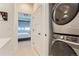 Convenient in-unit laundry area with modern stackable washer and dryer in a bright hallway with plank flooring at 4100 E Iliff Ave # 4, Denver, CO 80222