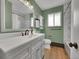 Bathroom featuring neutral walls and flooring, vanity, toilet and window with tub and tiled shower in background at 461 Nome St, Aurora, CO 80010