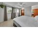 Bright bedroom features a ceiling fan, multiple windows with curtains and a glimpse into the attached bathroom at 461 Nome St, Aurora, CO 80010