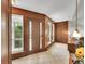 Warm foyer featuring wood paneling, tile flooring, and ample natural light from large windows at 461 Nome St, Aurora, CO 80010