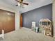 Spacious playroom with neutral carpet, dark blue accent wall and an array of toys and play furniture at 461 Nome St, Aurora, CO 80010