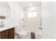Clean bathroom with a vanity, toilet, and a shower-tub combination with white tile and modern fixtures at 2257 S Lowell Blvd, Denver, CO 80219