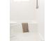 Modern bathroom featuring a toilet, tub with shower, and neutral-toned towel, showcasing a clean design at 2257 S Lowell Blvd, Denver, CO 80219