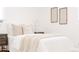 Serene bedroom with neutral tones, featuring a comfortable bed with layered bedding and simple decor at 2257 S Lowell Blvd, Denver, CO 80219