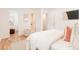 Bright bedroom showcases hardwood floors with a glimpse into an ensuite bathroom and closet space at 2257 S Lowell Blvd, Denver, CO 80219
