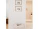 Bright hallway with hardwood floors showcases artwork and a glimpse into a modern bathroom at 2257 S Lowell Blvd, Denver, CO 80219