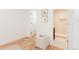 Bright hallway with hardwood floors leading to a bathroom with a glass-enclosed shower at 2257 S Lowell Blvd, Denver, CO 80219
