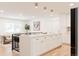 Open-concept kitchen with large island, white cabinets, and view to living room at 2257 S Lowell Blvd, Denver, CO 80219