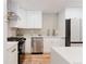 Modern kitchen with stainless steel appliances, white cabinets, and quartz countertops at 2257 S Lowell Blvd, Denver, CO 80219