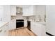 Modern kitchen featuring white cabinets, stainless steel appliances, and hardwood floors at 2257 S Lowell Blvd, Denver, CO 80219
