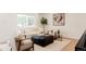 Bright living room featuring plush seating, a decorative tree, and large window at 2257 S Lowell Blvd, Denver, CO 80219