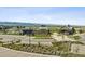 Aerial view of community center amenities: pool, clubhouse, parking, and green spaces with mountain backdrop at 11053 Bright Sky Cir, Littleton, CO 80125