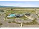 Aerial view of community center amenities: pool, clubhouse, parking, and green spaces with lake view at 11053 Bright Sky Cir, Littleton, CO 80125